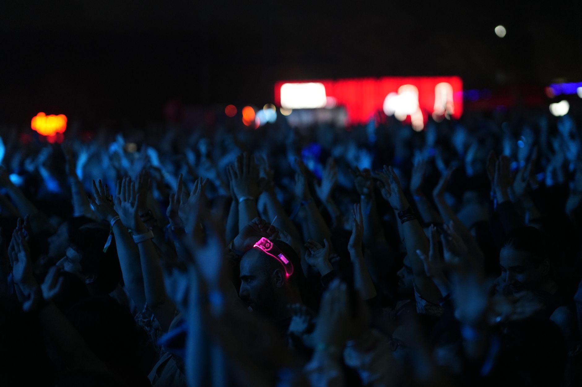 A lively concert scene with a crowd of people enjoying the music at night.